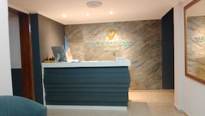 A reception desk with a sign reading 'punto sur AVENIDA' and a laptop on top.