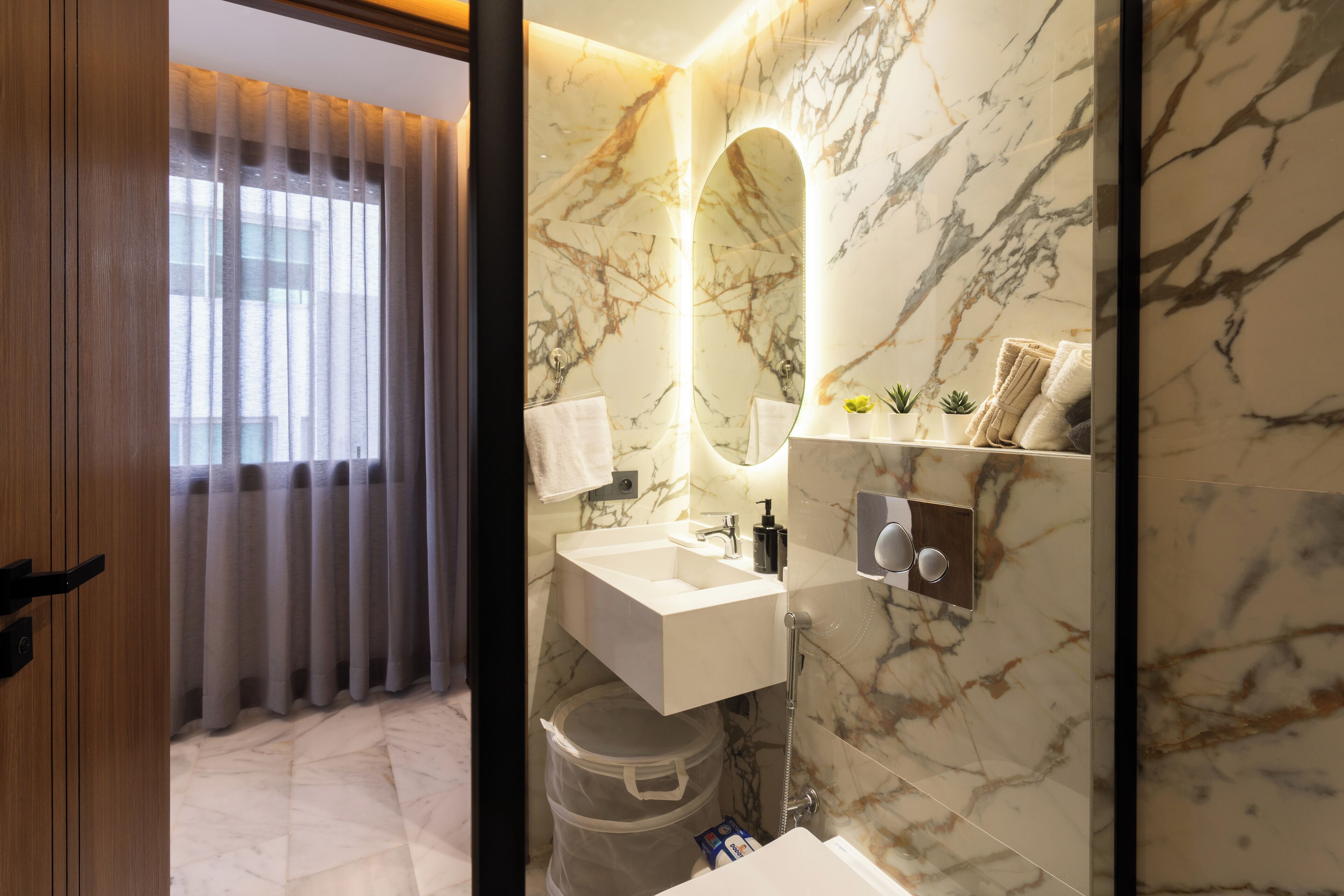 A modern bathroom with a marble backsplash, a built-in sink, and a mirror.