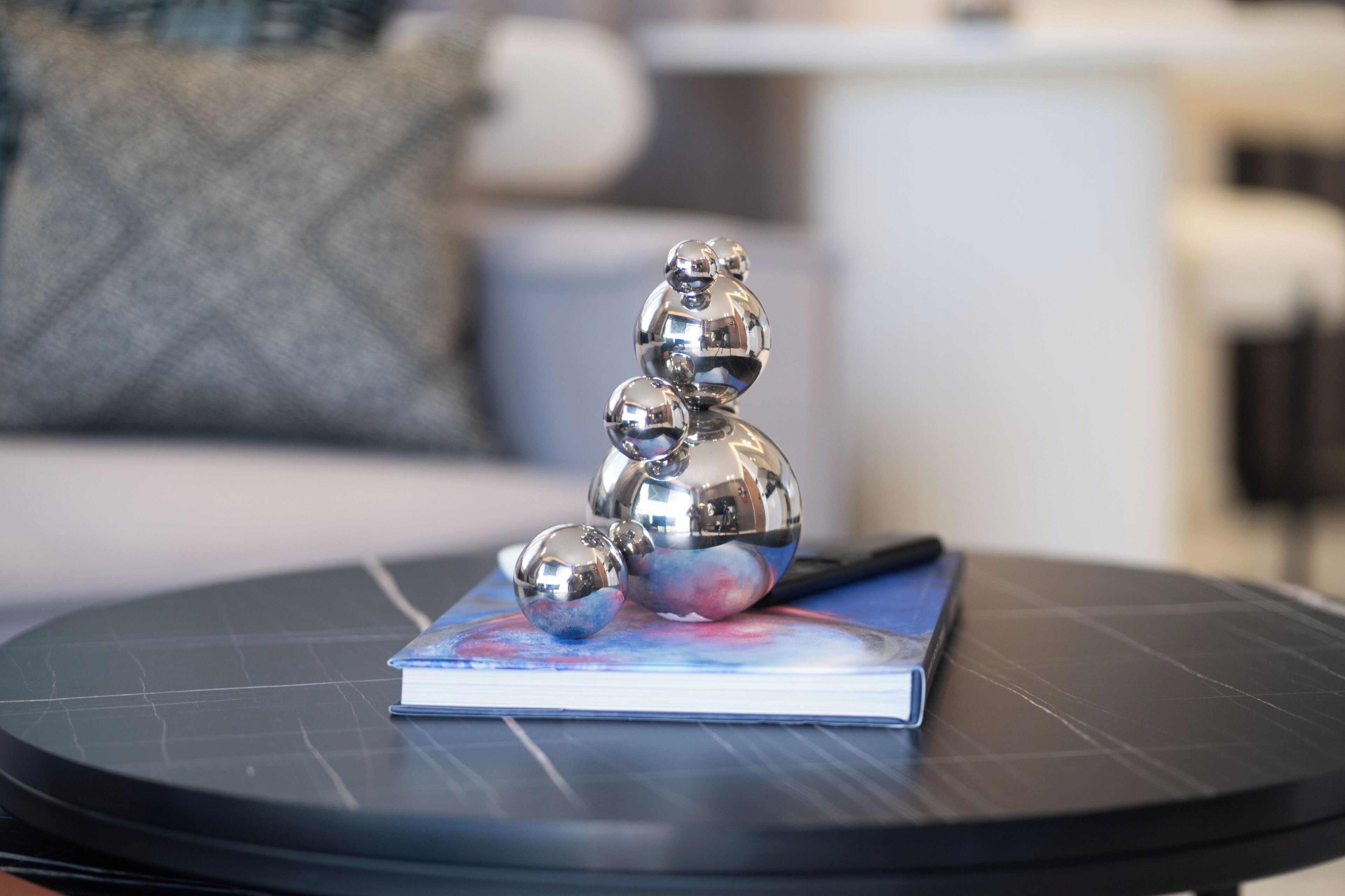 A metallic sculpture on a book on a round table.