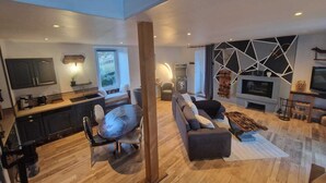 A modern living space with a kitchen, dining area, and seating area.