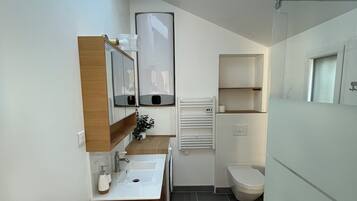 Chuveiro, toalhas de banho, sabonete, papel higiênico