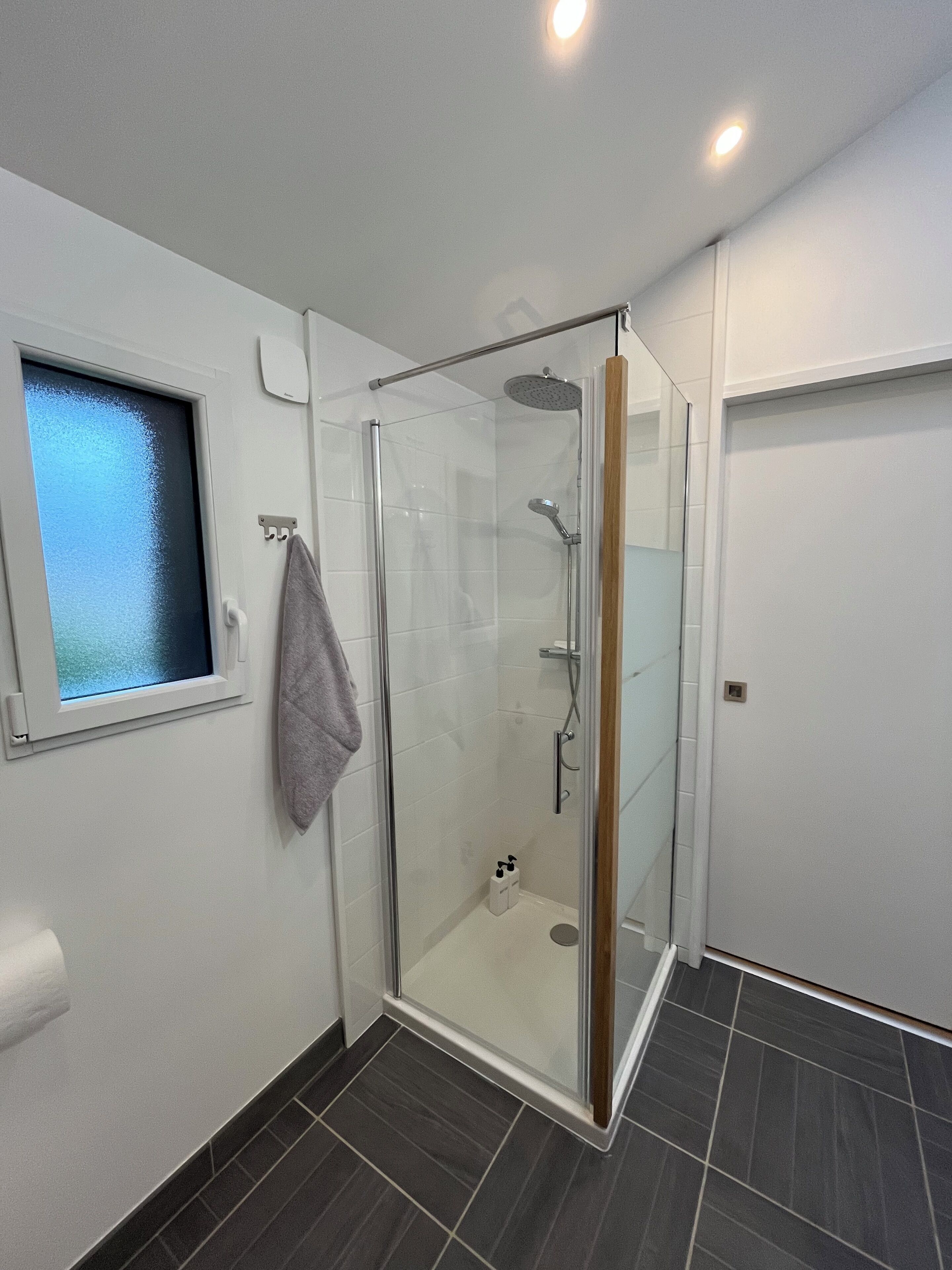 Chuveiro, toalhas de banho, sabonete, papel higiênico