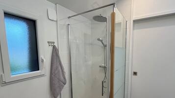 Chuveiro, toalhas de banho, sabonete, papel higiênico