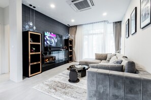 Appartement, 3 slaapkamers, privézwembad | Woonruimte | Een 65-inch smart-tv met digitale zenders en een open haard