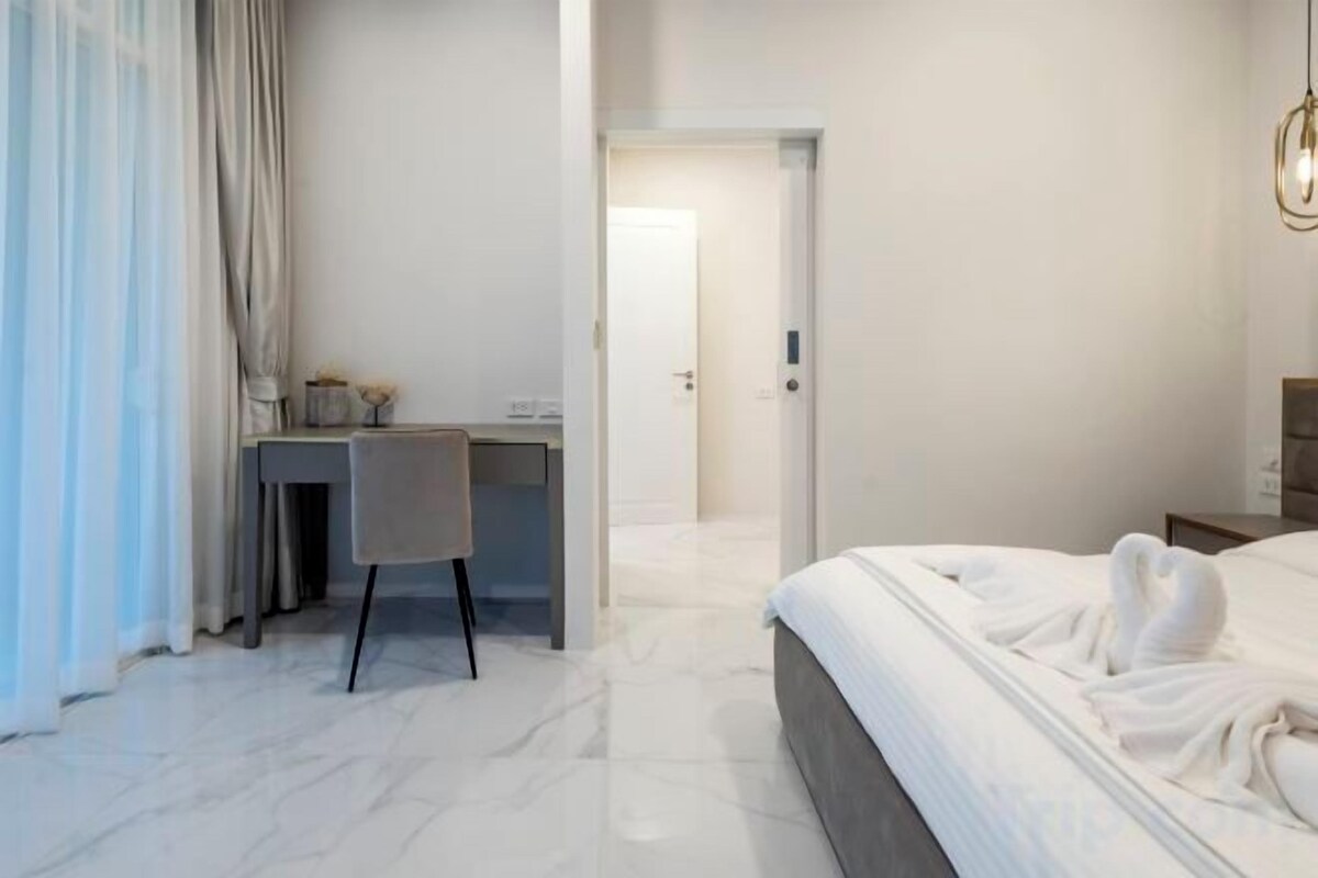 A hotel room with a bed, a desk, and a chair.