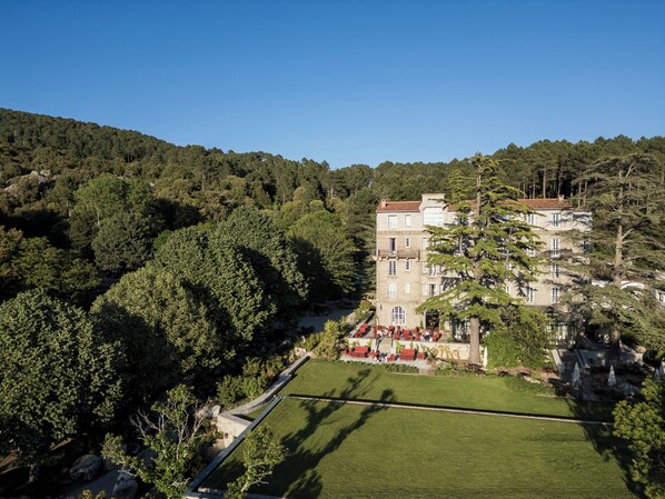 A large building with multiple floors, surrounded by lush greenery and a well-maintained lawn.