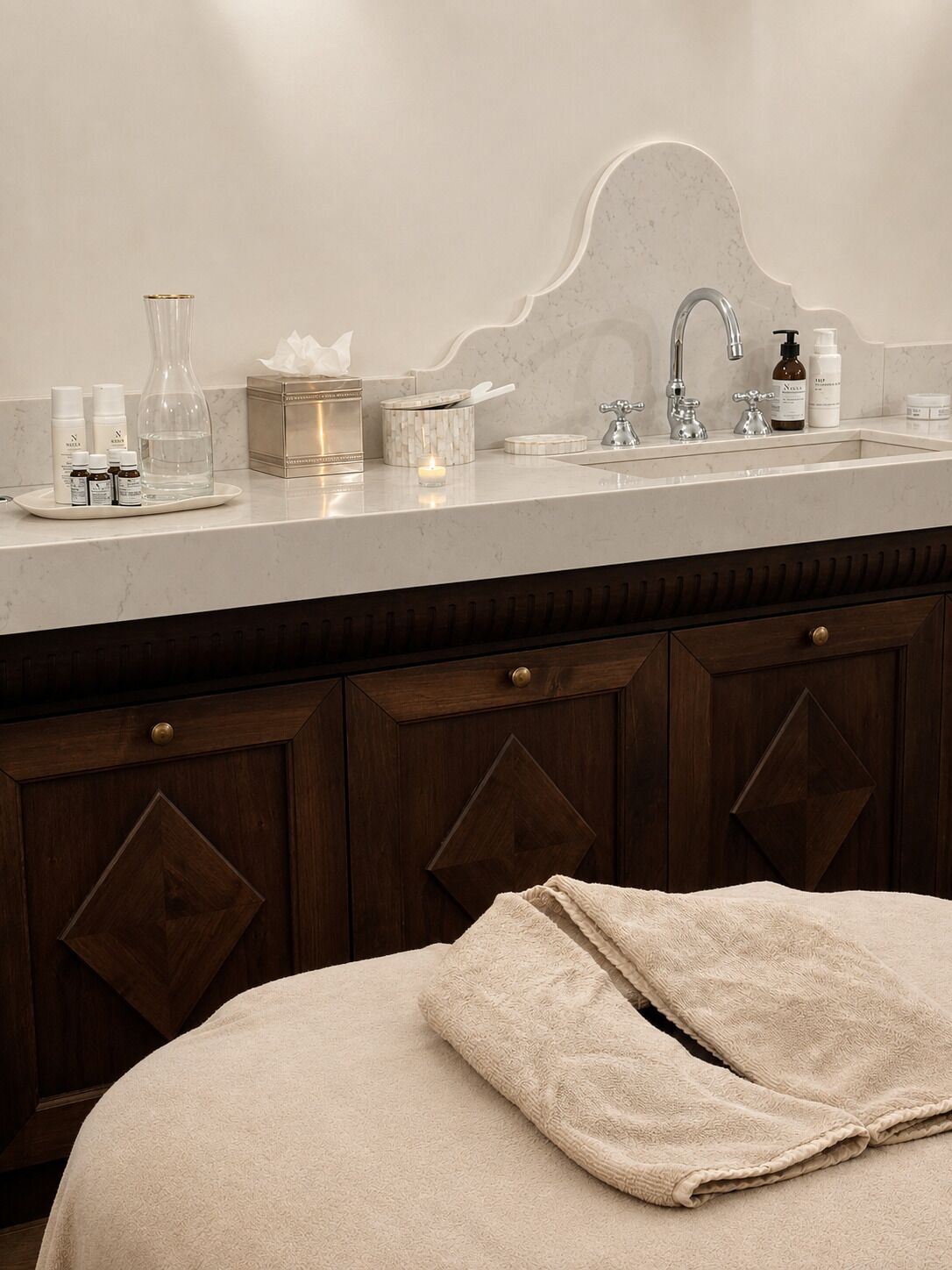 A bathroom with a marble countertop, a sink, and a wooden cabinet.