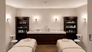 A hotel room with a double bed, a large mirror, a vanity with a sink, and two side tables.
