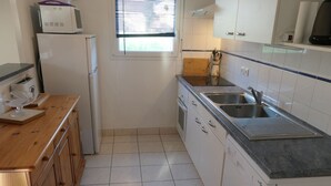 A kitchen with white cabinets, a stainless steel sink, and a wooden countertop. - House in Sarzeau, 3 bedrooms, near beach and shops, pets allowed, internet (Sarzeau)