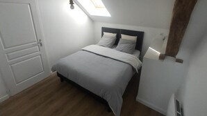 A bedroom with a bed, a skylight, a door, and a radiator. - Countryside Cottage with Wifi and Pets Allowed (Saint-Bonnet-de-Four)