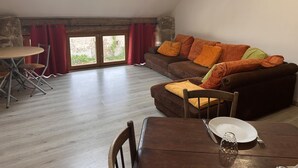 A loft-style living space with a dining area, a sofa with cushions, and a skylight. - Countryside Cottage with Wifi and Pets Allowed (Saint-Bonnet-de-Four)