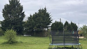 A trampoline in a grassy field with trees in the background. - Countryside Cottage with Wifi and Pets Allowed (Saint-Bonnet-de-Four)