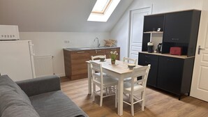 A compact living space with a kitchenette, a dining area, and a sofa. - Country Escape: Renovated Cottage with Pets Allowed (Saint-Bonnet-de-Four)