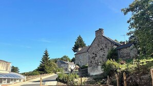A backyard with a wooden fence, a table with chairs, and a grassy area. - La Maison de Victoire et Alix - house with garden in the heart of Pontrieux (Pontrieux)