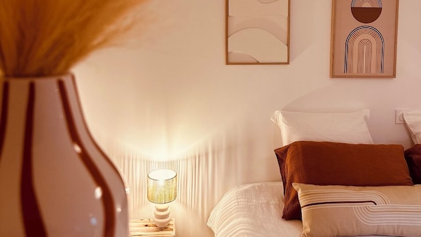A bedroom with a bed, a nightstand with a lamp, and two framed artworks on the wall. - La Maison de Victoire et Alix - house with garden in the heart of Pontrieux (Pontrieux)