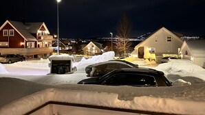 A residential area at night with houses, a street light, and snow-covered ground. - Kvaloysletta - 2 Bed Apartment - Free Parking (Tromsø)