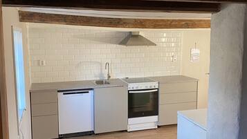 Huis | Privékeuken | Een minikoelkast, een microgolfoven, een kookplaat, een kinderstoel