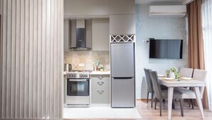 Una cucina moderna con forno a incasso, frigorifero e zona pranzo con tavolo e sedie.