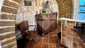 A room with a stone archway, a wooden cabinet, a chair, and a table. - The Tower "UnaNotteaCasaMia" (Sacrofano)