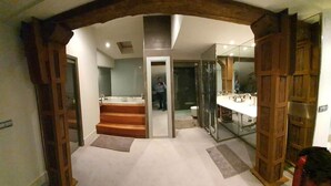 A modern bathroom with a glass shower enclosure, a bathtub, and a vanity with a mirror.