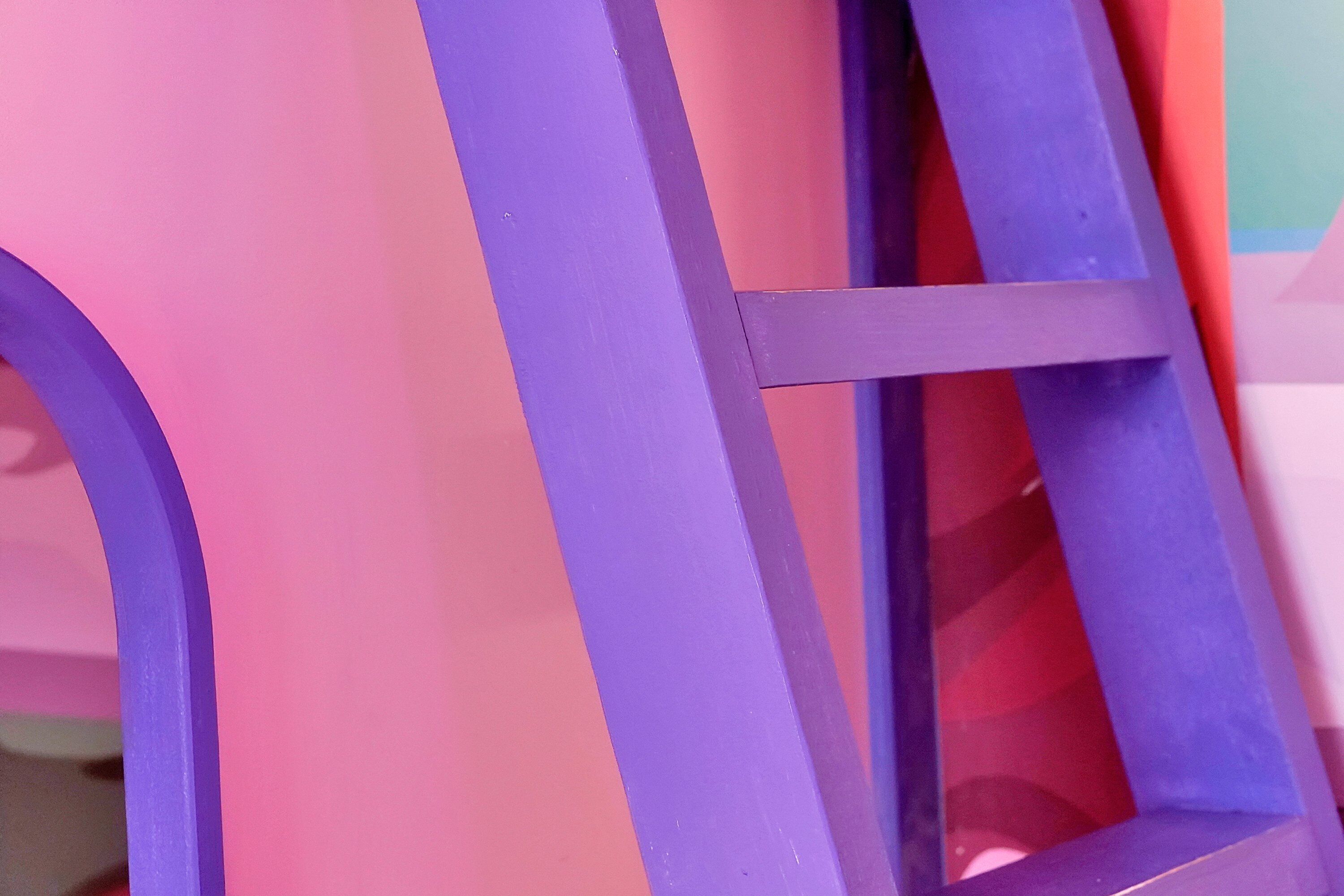 A close-up of a purple metal structure, likely part of a piece of furniture or equipment.