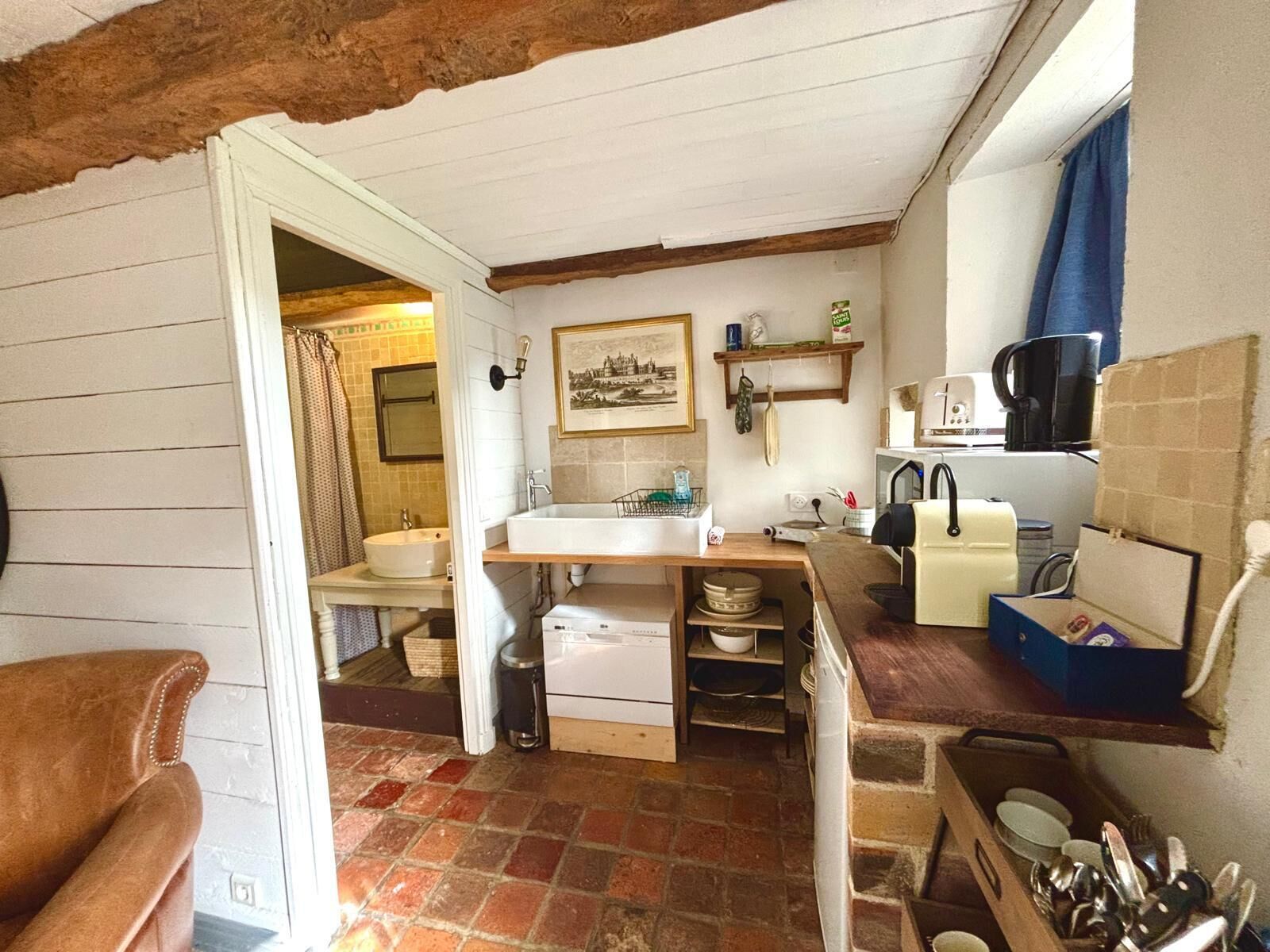 A compact kitchen with a sink, a stove, and a coffee maker.
