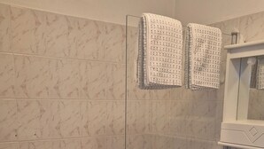 A bathroom with a bathtub, a shower, and a sink. - Studio per week  (Menton)