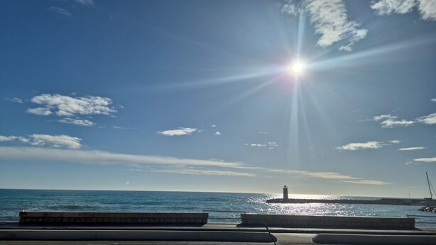 A coastal scene with a lighthouse, clear sky, and calm sea. - Studio per week  (Menton)