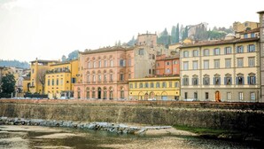 A row of colorful historic buildings along a river. - Luxurious 6-Bedroom Apartment in a Historic Palazzo with Panoramic Terrace





 (Firenze)