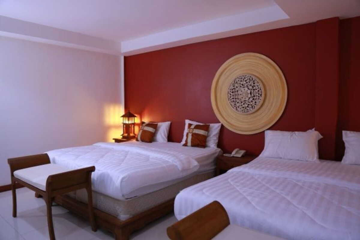 Una habitación de hotel con dos camas, una lámpara de pared y un adorno mural.