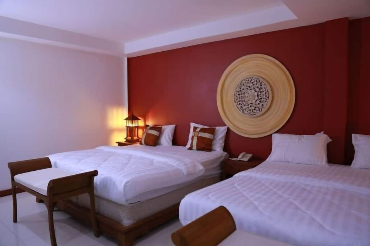 Une chambre d’hôtel avec deux lits, une lampe fixée au mur et un élément décoratif mural.
