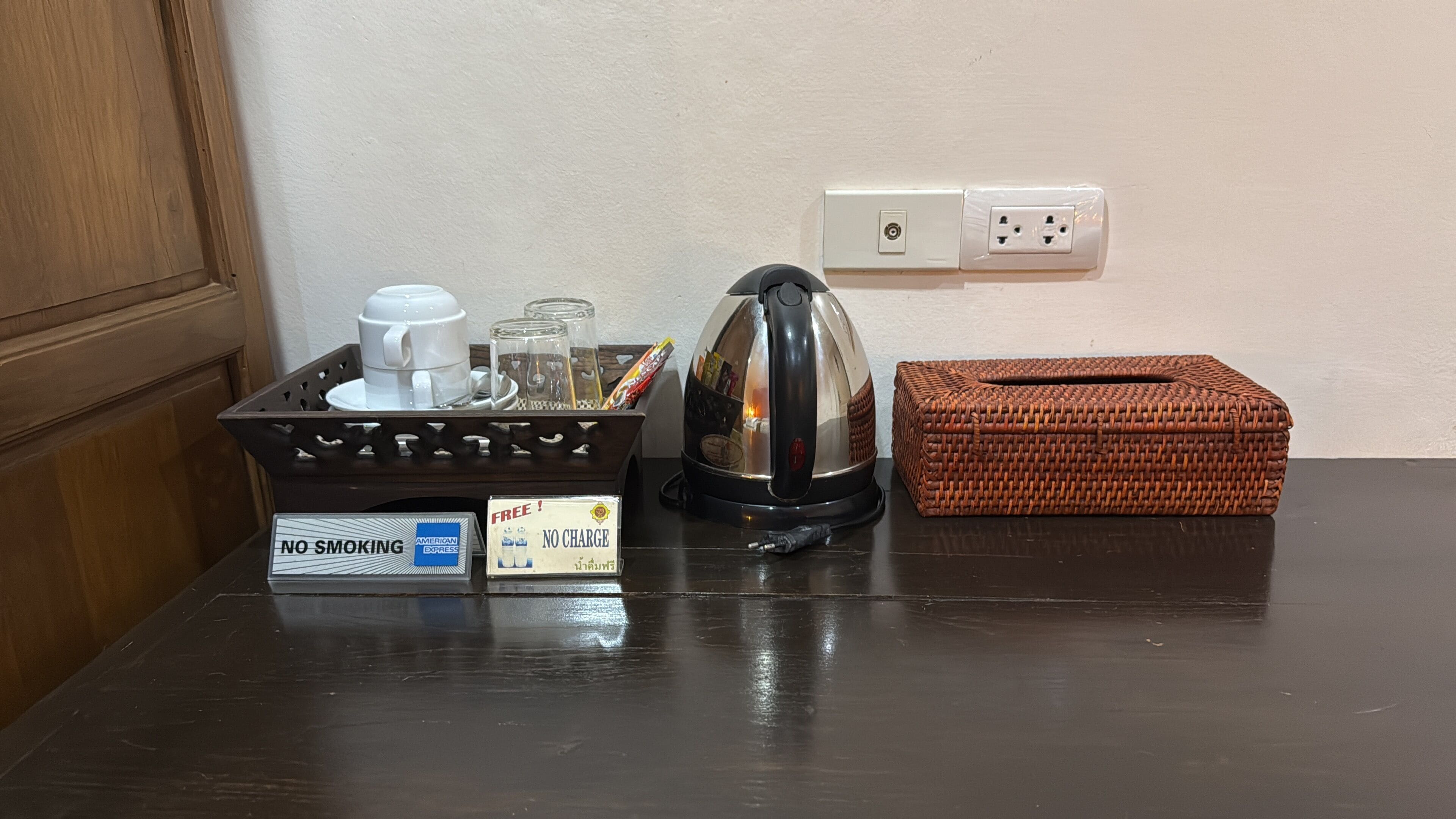 Un comptoir de cuisine avec une machine à café, un panier et un panneau indiquant qu’il est interdit de fumer.