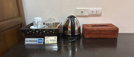 A kitchen counter with a coffee maker, a basket, and a sign indicating no smoking.