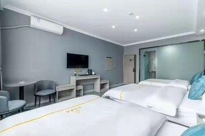 A hotel room with two beds, a desk, a chair, a television, and a minibar. - Panda House Hotel (Chengdu)