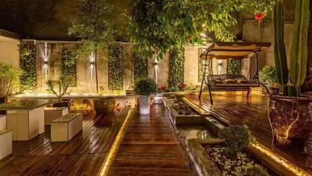 An indoor garden with a wooden floor, potted plants, and a seating area. - Panda House Hotel (Chengdu)