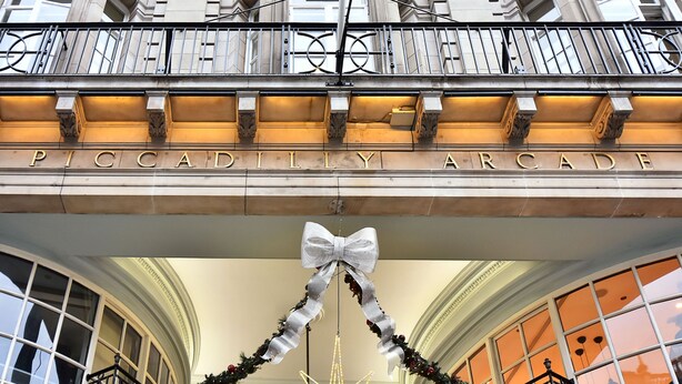 La façade extérieure de la galerie marchande de Piccadilly, avec son entrée imposante et un grand nœud décoratif.