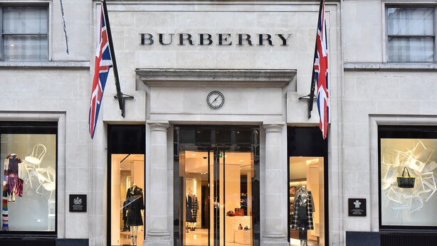 Een Burberry winkel met grote glazen ramen waar kleding wordt tentoongesteld.