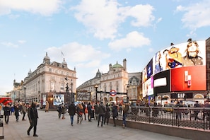 A busy urban square with historic buildings, a large digital billboard, and a red double-decker bus. - Albemarle Elegance IV - 37as4 (London)