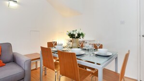 A dining area with a glass table set for four, surrounded by wooden chairs. - Cromwell Style I - 605pw (London)