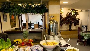 Un bufé con diversas opciones de comida, entre ellas frutas, verduras y productos lácteos.