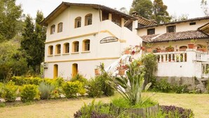 Un edificio de dos plantas con un jardín delantero.