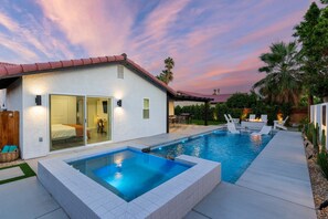A modern house with a swimming pool, a patio with outdoor furniture, and a view of the sunset. - 3-bedroom Fireplace Stunning Spanish Home (Indio)