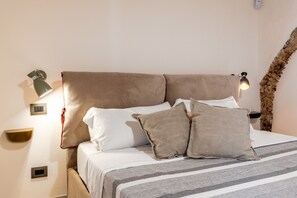 A neatly made bed with a striped bedspread, two pillows, and a headboard. - Nicu Amuri con Terrazza a Noto by Wonderful Italy (Noto)