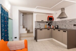 A modern kitchen with a built-in stove, microwave, and stainless steel range hood. - Nicu Amuri con Terrazza a Noto by Wonderful Italy (Noto)