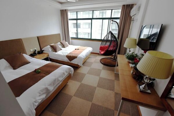 A hotel room with two beds, a hanging chair, a desk with a lamp, and a TV. - Wangyouju (Huangshan City)