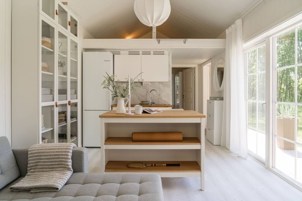 A modern kitchen with white cabinetry, a wooden countertop, and a built-in oven.