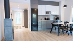 Une cuisine moderne dotée d’un îlot central, d’appareils électroménagers en acier inoxydable et d’un coin repas avec une table et des chaises.