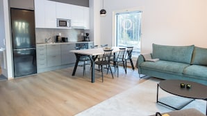 Une cuisine moderne avec un coin repas, un canapé et une table basse.