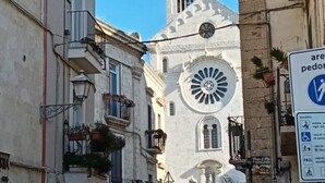 A historic building with a clock tower and a sign indicating pedestrian access. - Dimora D'Archi in the beating heart of Bari's Borgo Antico  (Bari)