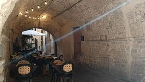 An indoor dining area with stone walls, tables, and chairs. - Dimora D'Archi in the beating heart of Bari's Borgo Antico  (Bari)